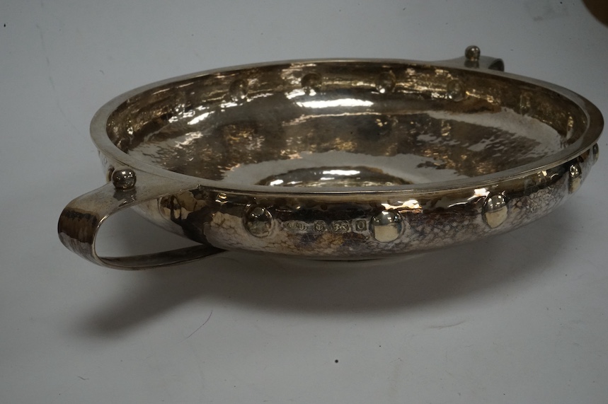 A George V Arts & Crafts planished silver two handled shallow fruit bowl, by Albert Edward Jones, Birmingham, 1913, lacking glass insert?, diameter 19.7cm (excluding handles), 9.2oz. Condition - fair